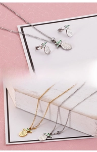 Detailed view of pineapple necklace and earrings set with green enamel and small crystals