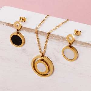 Dettaglio di set collana e orecchini in acciaio placcato oro con numeri romani incisi