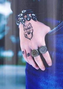 Close-up of a men's vintage Viking rune ring and skull bead bracelet on a model