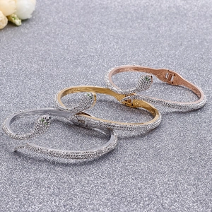Elegant snake shaped bracelet with crystals and green eyes in gold and silver finish