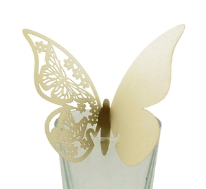 Detail showing laser-cut butterfly place card with hollow pattern on wine glass