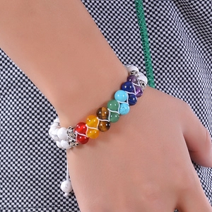 Hand wearing a double-layer 7 chakra beaded bracelet with turquoise and amethyst stones
