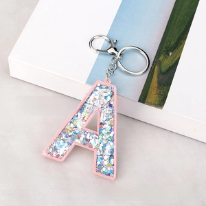 Detail of pink acrylic letter A keychain with colorful laser sequins and silver clasp