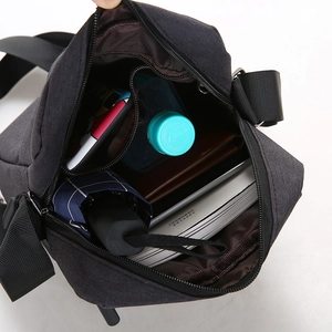 Large capacity black canvas crossbody bag showing interior storage for umbrella and water bottle