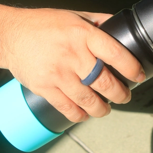 Close-up of a dark grey silicone ring with geometric patterns for outdoor sports