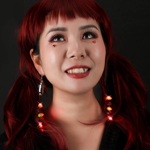 Luminous LED Christmas bulb earrings with colorful light strings on a festive model