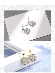 Detail of sparkling snowflake stud earrings in silver and gold finishes with zircons