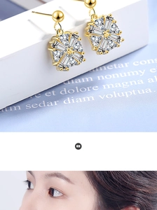 Macro detail of gold flower earrings with baguette cut cubic zirconia in a radial design