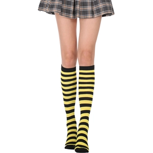 Detail of yellow and black striped knee-high knit socks paired with a plaid skirt