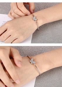 Close-up of minimalist silver butterfly bangle with micro-pave detailing on wrist