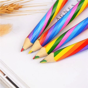 Macro shot of four rainbow pencils with multi-color lead on white paper with dried wheat