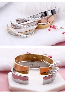 Macro detail of cross-over pearl and rhinestone bracelet with gold finish and hinge