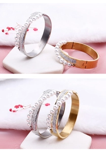 Close-up of gold and silver steel bangles featuring pearls and sparkling zircon pavé
