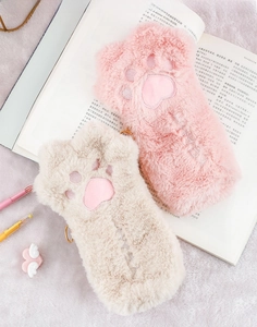 Dettaglio di astucci in peluche a zampa di gatto rosa e beige con morbidi cuori ricamati