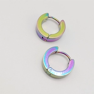 Vue macro de boucles d'oreilles créoles en métal dégradé arc-en-ciel poli et brillant