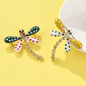 Detailed macro view of colorful enamel dragonfly brooches with rhinestones and gold plating
