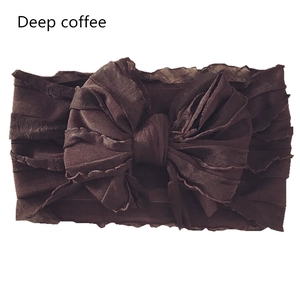 Detailed view of wide elastic baby headband with large layered bow in deep coffee