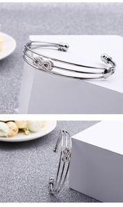 Vue détaillée du bracelet infini argenté à triple couche avec des accents de zircon