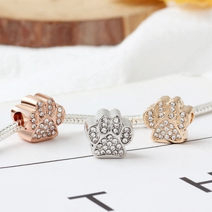 Three rhinestone animal paw print charms in rose gold, silver, and gold on snake chain