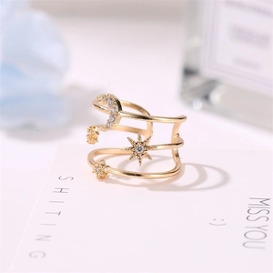 Macro shot of three-layered gold star and moon ring with cubic zirconia inlay details