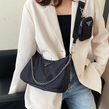 Détail du cabas en nylon noir avec chaîne argentée et petite pochette assortie