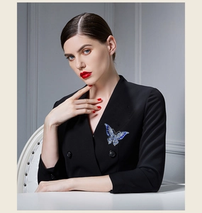 Macro detail of a vintage crystal butterfly brooch pinned on a black professional blazer