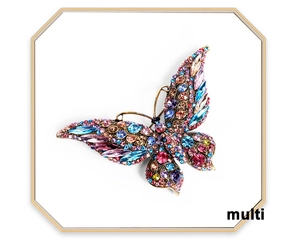 Detailed close-up of multi-colored crystal butterfly brooch with golden base setting