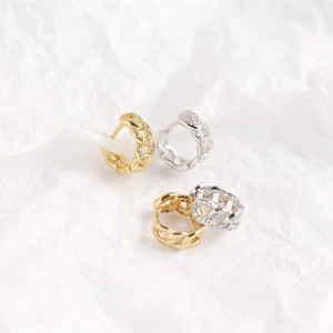 Detailed view of silver and gold geometric chain earrings with sparkling cubic zirconia