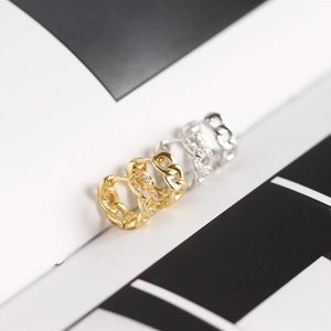 Close-up of gold and silver S925 sterling silver Cuban link earrings with small pavé crystals