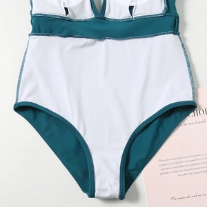 Detail view of teal and white patchwork bikini showing fine stitching and inner pads
