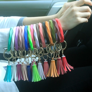 Silicone key ring bracelet with PU tassel detail shown on wrist in various colors