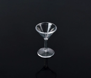 Macro di un bicchiere da martini in miniatura in plastica trasparente su fondo nero