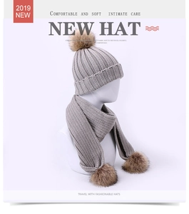 Détail de l'ensemble bonnet et écharpe en tricot gris avec pompons en fausse fourrure