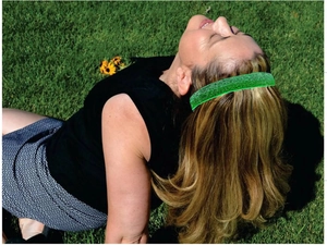 Close-up of a sparkling green sequin elastic headband worn on blonde hair outdoors