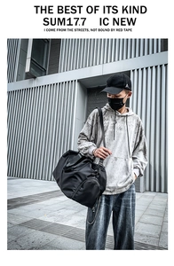 Men's black waterproof travel duffel bag with shoulder strap in an urban outdoor setting