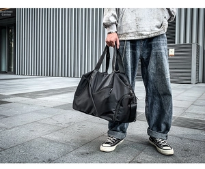 Detail of black large capacity travel duffel bag with side zipper storage compartment