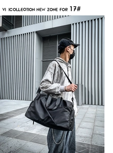 Black waterproof travel bag shown worn by a model against a modern architectural background