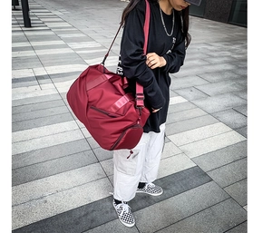 Outdoor urban shot of a red large capacity sports travel bag with waterproof compartment