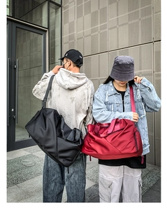 Waterproof travel duffel bag in black and red colors with adjustable shoulder straps