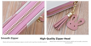 Close-up of smooth gold zipper with pink tassel and leather rabbit charm on a purse