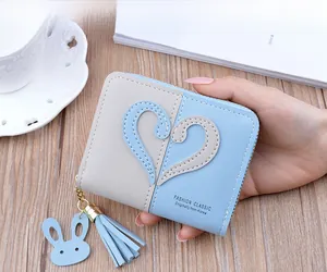 Detail of blue and grey patchwork coin purse with heart patches and rabbit charm