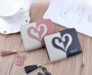 Detail of short PU leather wallets with heart patch and cute rabbit tassel charm