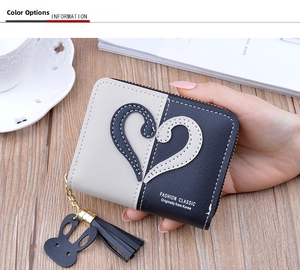 Close-up of a two-tone zip wallet with heart patchwork and stylish black tassel detail