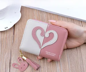 Detail of pink and grey leather wallet with heart applique, tassel and rabbit pendant