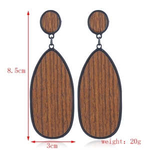 Détail de boucles d'oreilles en bois en forme de goutte, dimensions 8,5x3cm et poids 20g