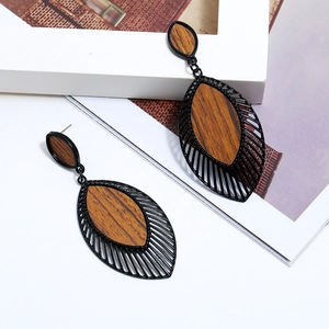 Boucles d'oreilles rétro en bois avec cadre en alliage noir sur fond de magazine