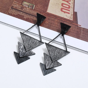 Vue détaillée de boucles d'oreilles triangulaires multicouches noires à texture brossée