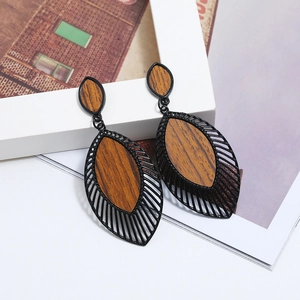 Vue détaillée des boucles d'oreilles en forme de feuille avec métal noir et texture bois