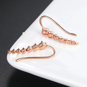 Minimalist rose gold earrings with colorful zircon stones in a wavy hanging design