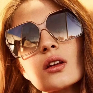 Close-up of stylish square oversized sunglasses with gradient lenses on female model